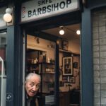 A elderly guy sticks his head in the barbershop