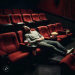 A Man Lay Sprawled Across Three Seats In The Cinema